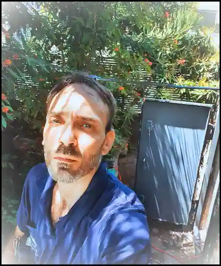טכנאי לאחר התקנה של דלת ומשקוף מקלט שנמצא מאחוריו בתמונה.