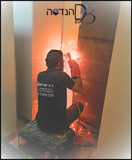 טכנאי מרתך ומחזק בחדר מקלט. לוגו של ד.ב הנדסה.